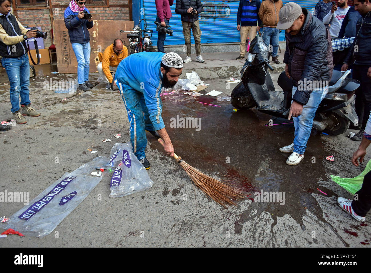 Un locale lavaggi delle macchie di sangue in prossimità del sito di attacco a Srinagar.Un non-locali è stato ucciso e diversi locali sono stati feriti quando una bomba è esplosa in un affollato mercato a Srinagar. Foto Stock