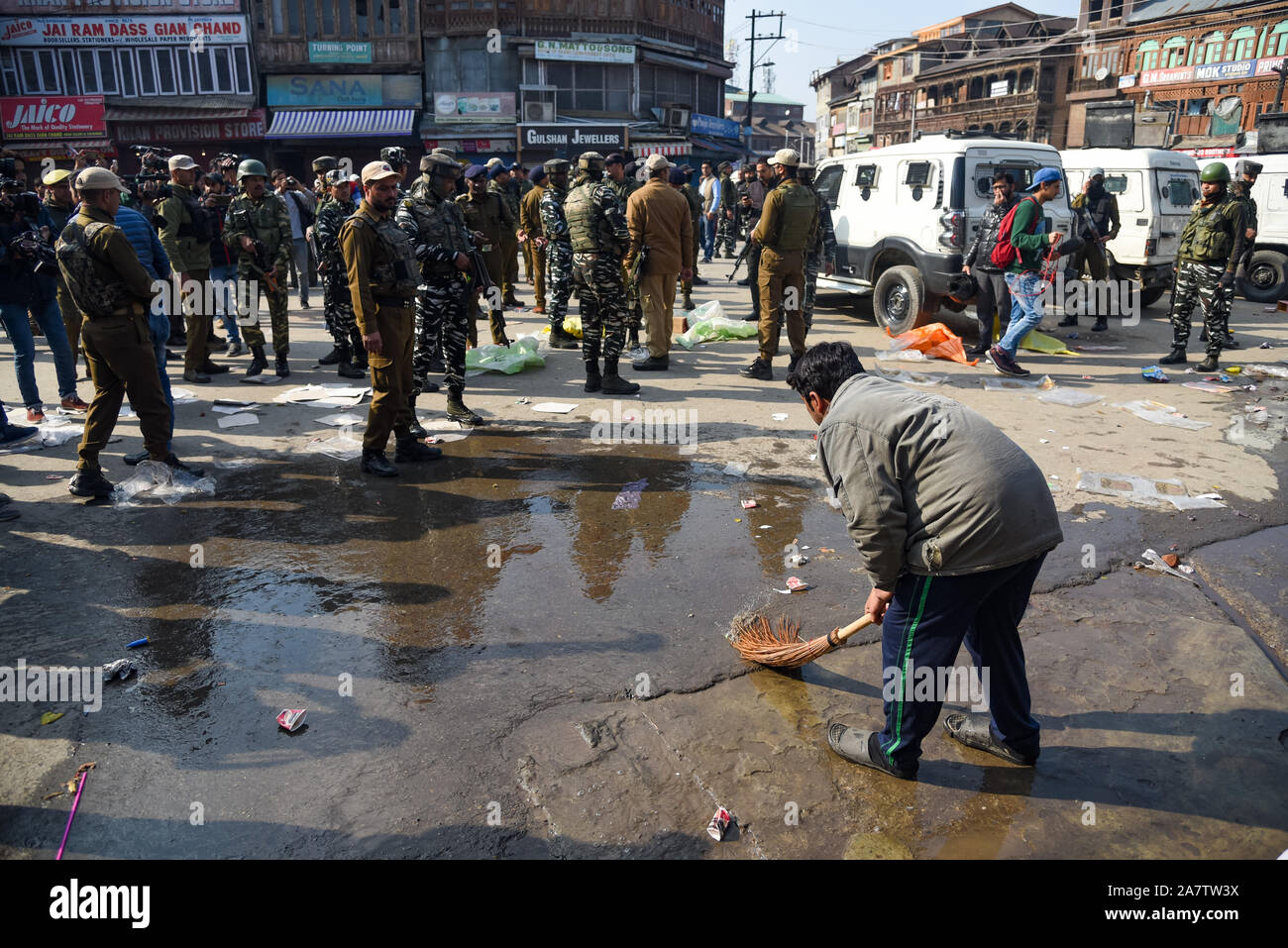 Un uomo lava il sangue come le forze indiane avviso sorge vicino al sito di Grenade blast in Srinagar.un non residente locale è stato ucciso mentre e almeno 40 persone tra cui tre personale delle forze di sicurezza sono rimasti feriti in un attentato a granate a Gonikhan area di Hari Singh High Street (HSHS) nel cuore di Srinagar. Foto Stock