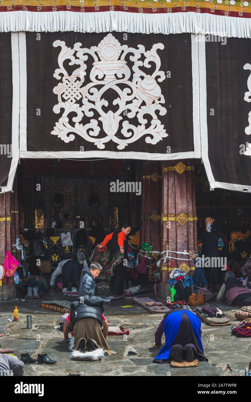 Lhasa, Cina - 4 Aprile 2019: buddisti di inginocchiarsi e pregare nel tempio di Jokhang a Lhasa, in Tibet. Il tempio è il santissimo in tutto il Tibet e uno che nelle vicinanze Foto Stock