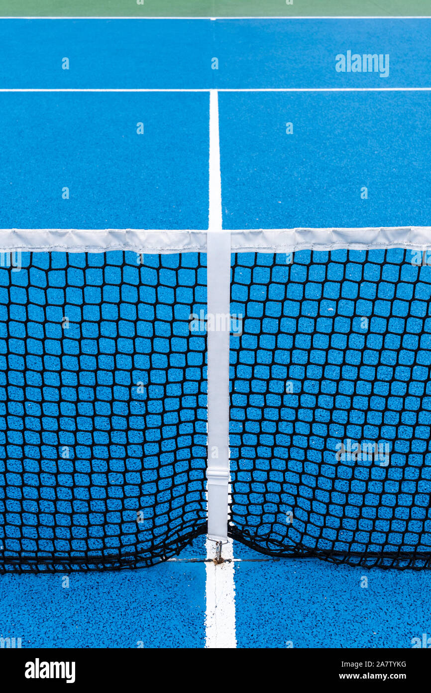 Dettaglio di un azzurro campo da tennis con nero sulla rete esterna. Sfondo di sport Foto Stock