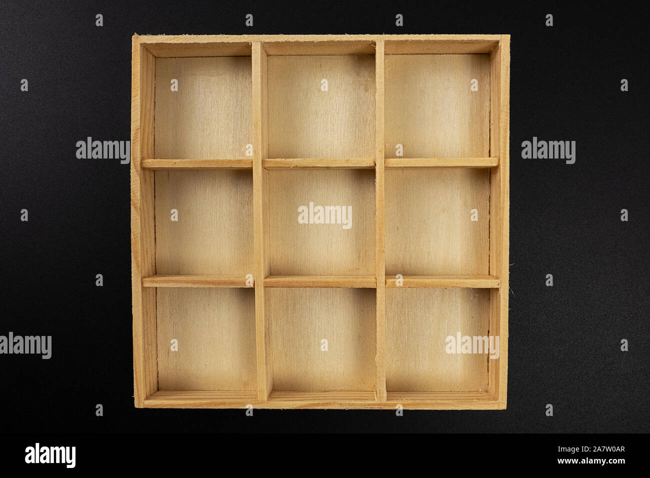 Vuoto piccola scatola di legno con nove divisioni isolati su sfondo nero Foto Stock