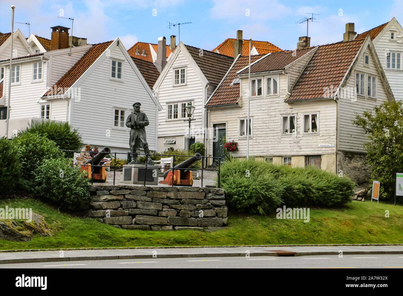 Statua del Vice Ammiraglio Thore Horve con bianco storiche case di legno come sfondo in Stavanger città vecchia. Foto Stock