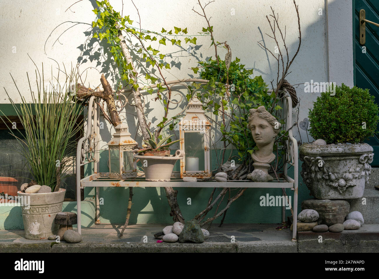 Vari oggetti decorativi con estetica vintage su una panchina situata su un marciapiede Foto Stock