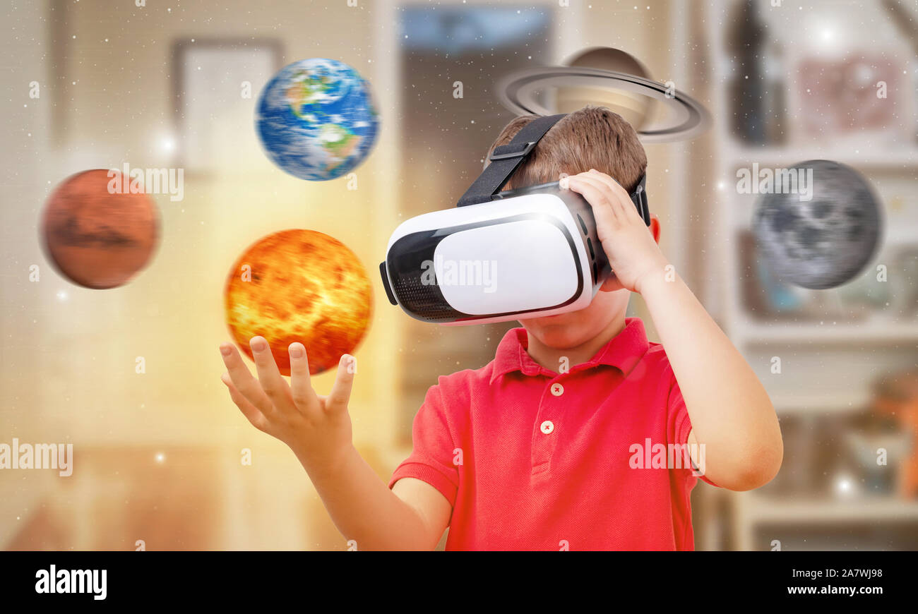 Ragazzo con occhiali per realtà virtuale detiene il sole nella sua stanza. Concetto di utilizzare le moderne tecnologie per l'apprendimento. Foto Stock