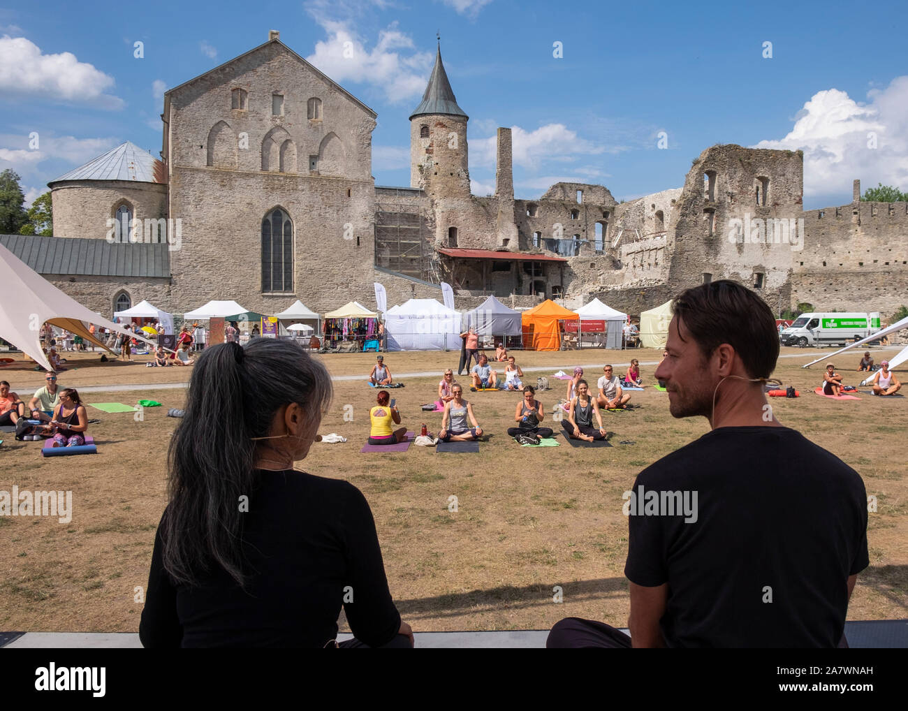 Gli insegnanti di yoga sul palco dando istruzioni per gli studenti presso il Festival di Yoga nel parco del castello di Haapsalu Haapsalu,, Estonia Foto Stock