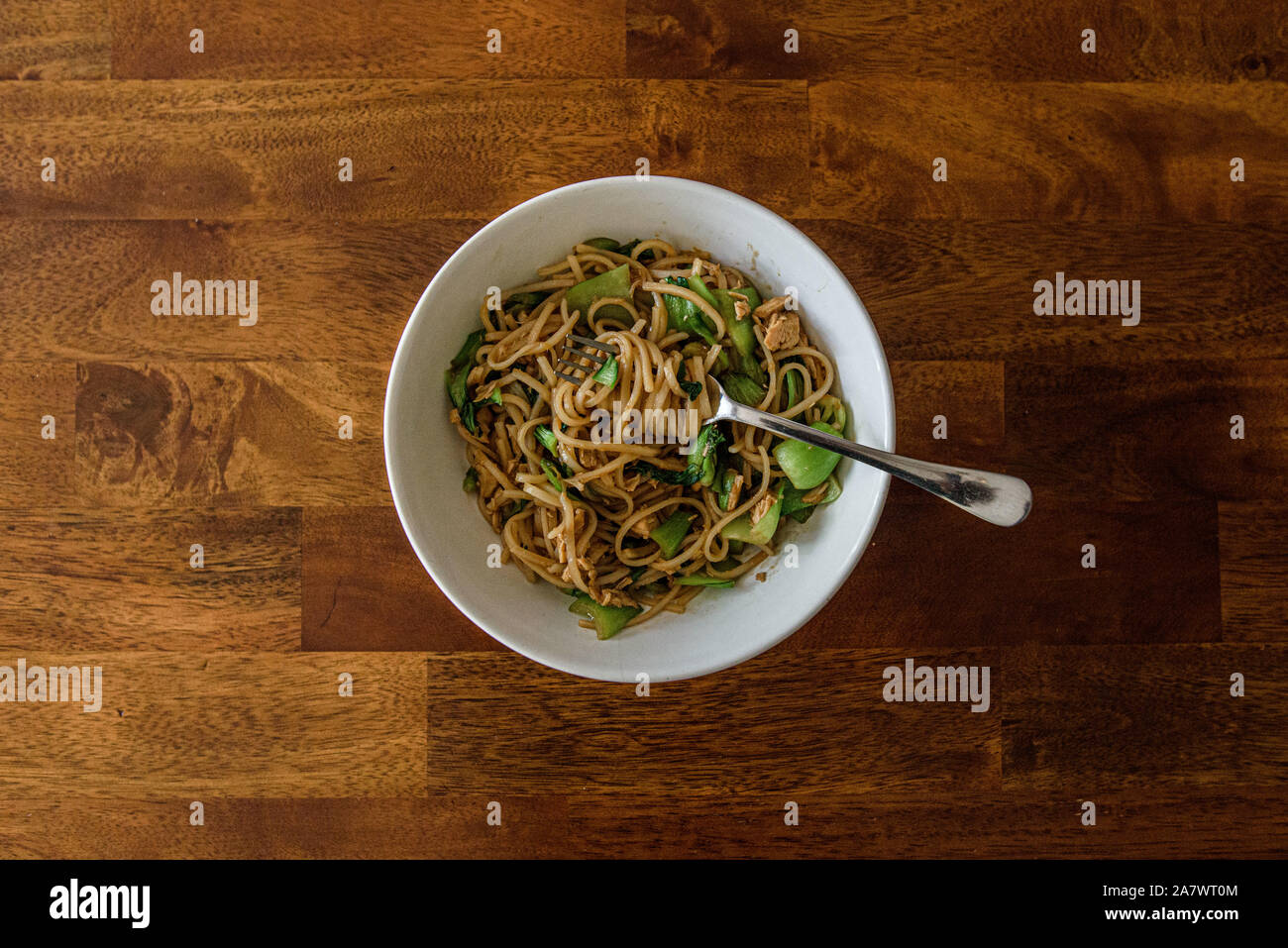 White ciotola riempita con noodle/piatto vegetariano e la forcella visto dal di sopra Foto Stock
