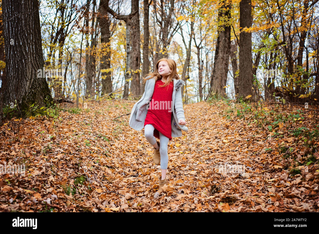 Giovani Capelli rossi ragazza a giocare al di fuori in foglie di autunno Foto Stock