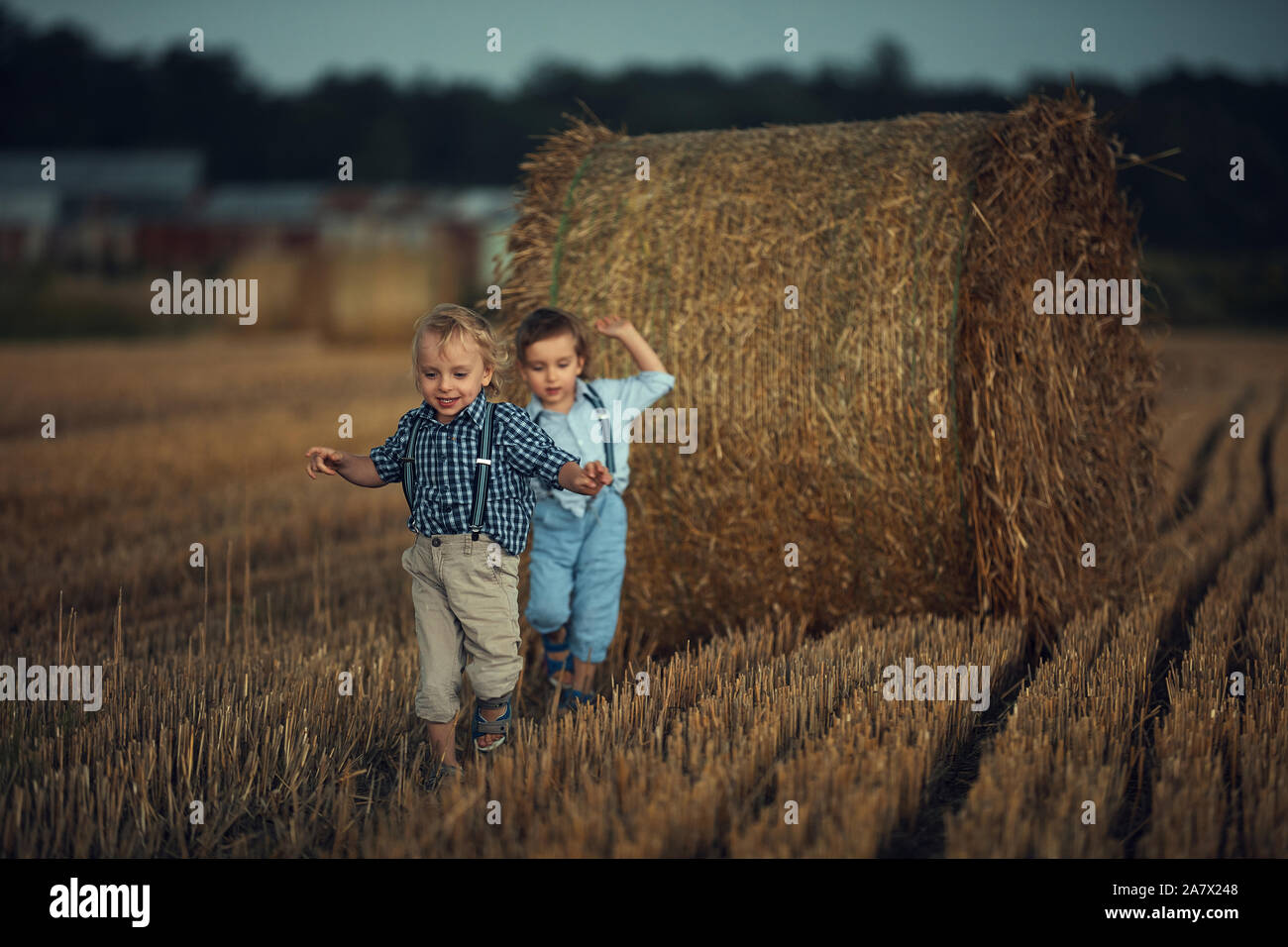 Allegro fratelli gemelli in esecuzione su terreni agricoli di estate Foto Stock
