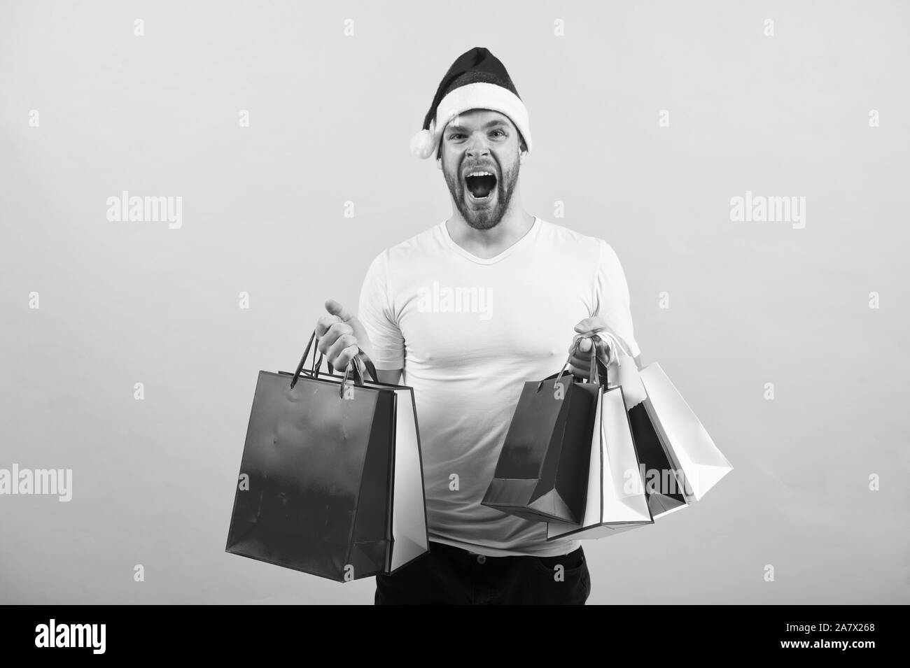 La mattina prima di Natale. consegna di regali di Natale. l uomo in santa hat tenere presente di natale. online shopping di Natale. Felice anno nuovo. Felice santa uomo su sfondo giallo. Divertimento natalizio. shoping in borsa. Foto Stock