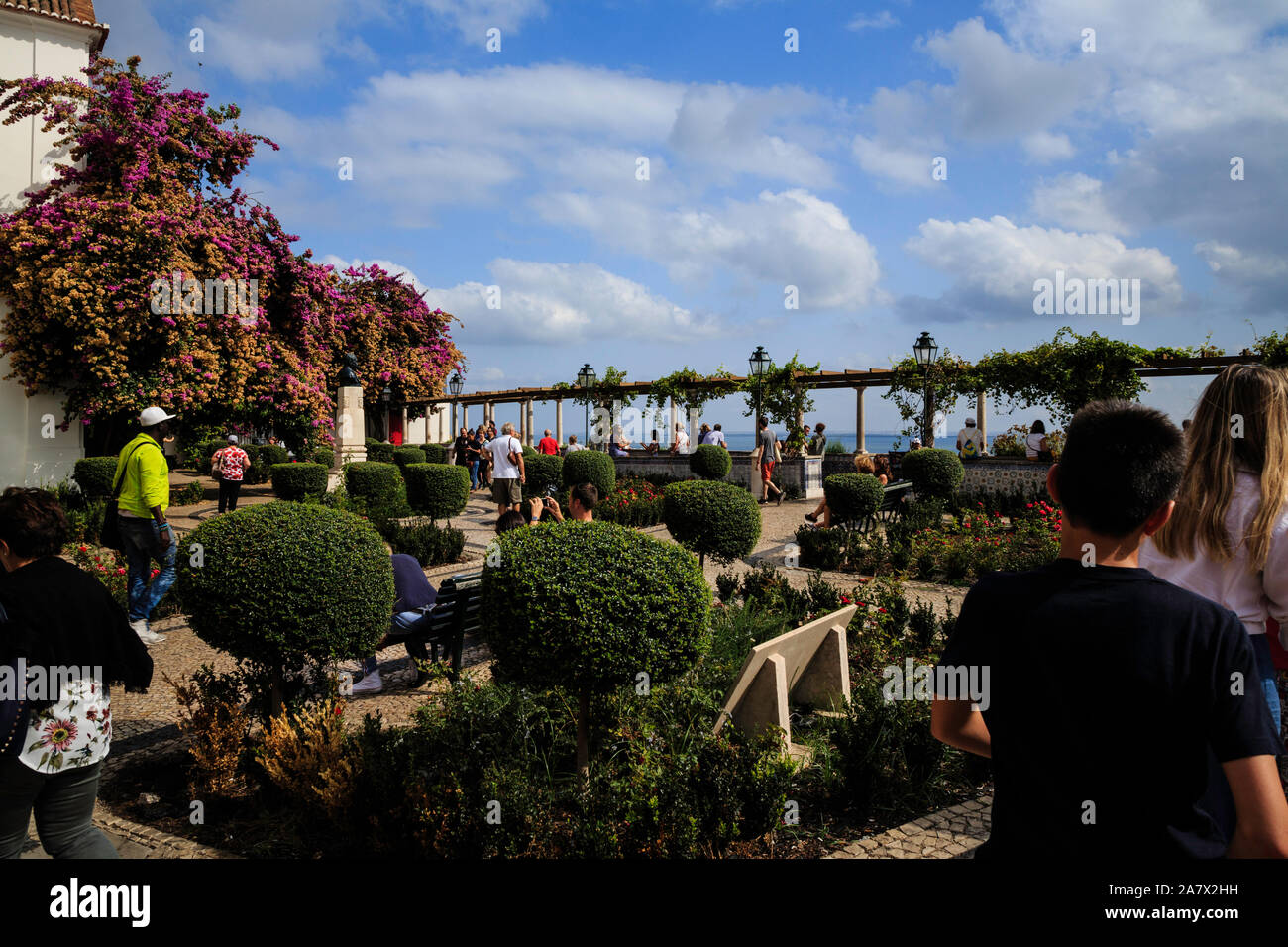 Visitatori passeggiare nei giardini di Lisbona, Portogallo la chiesetta di Santa Luiza che porta al suo popolare omonimo si affacciano il Miradouro de Santa Luiza. Foto Stock