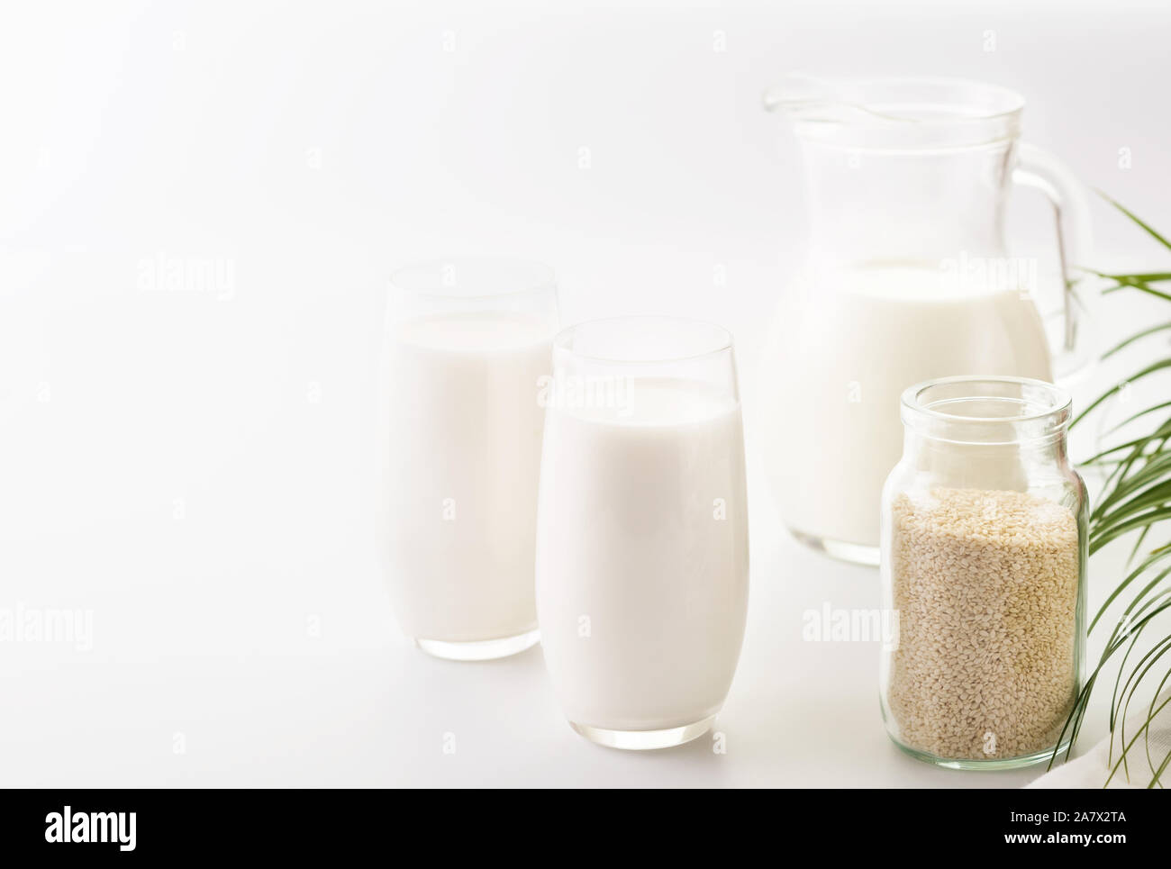 Semi di sesamo latte in un bicchiere. White Semi di sesamo su un tavolo. Cibo crudo.vegano alimenti alternativi, sesamo non-latte caseario. Foto Stock