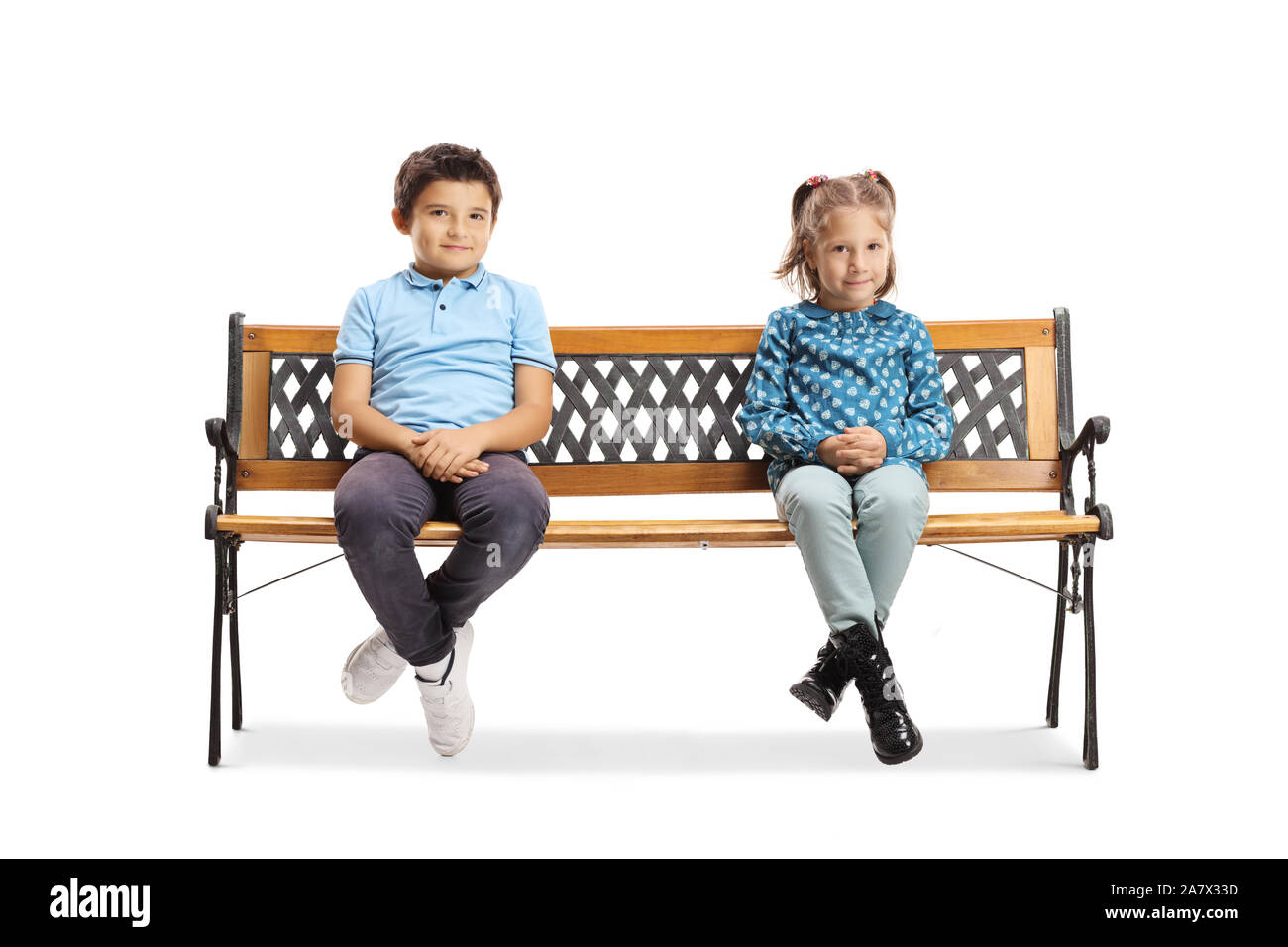 A piena lunghezza shot di un ragazzo e una ragazza seduta su una panchina e guardando la telecamera isolata su sfondo bianco Foto Stock