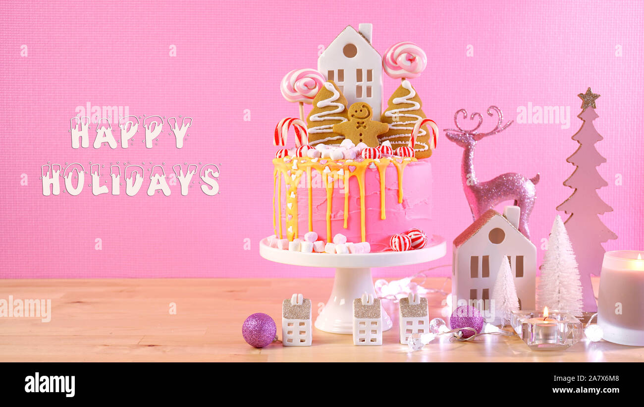 Candyland stile da fiaba di festa per i bambini la torta di Natale in rosa e oro messa in tavola con buone vacanze saluto messaggio di testo. Foto Stock