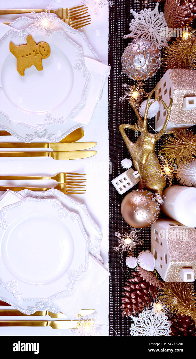 Festa di Natale vacanza la cena messa in tavola con oro rosa, bianco e oro centrotavola decorazioni eleganti e belle cina stoviglie, piatti overh laici Foto Stock