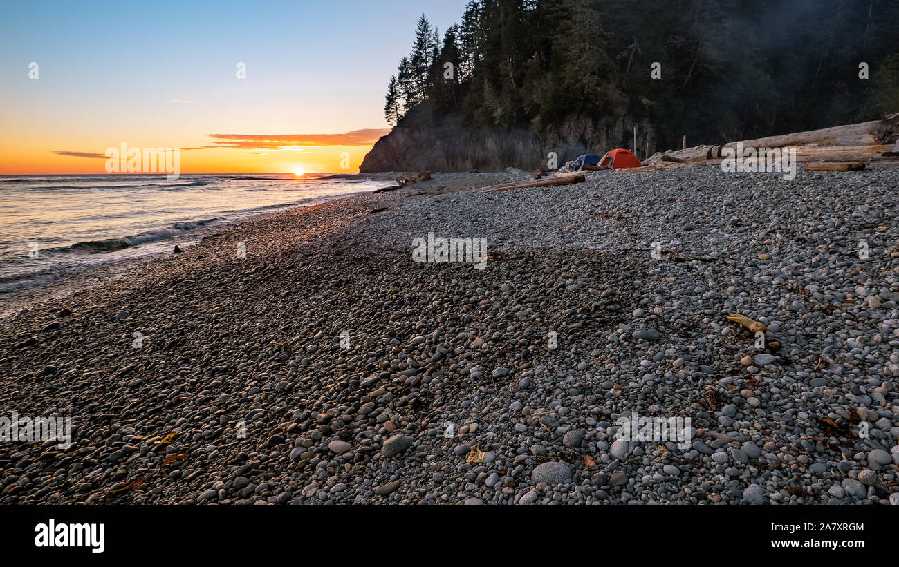 Camping con tende su una spiaggia rocciosa lungo la costa occidentale dell'isola di Vancouver sul west coast trail. Foto Stock