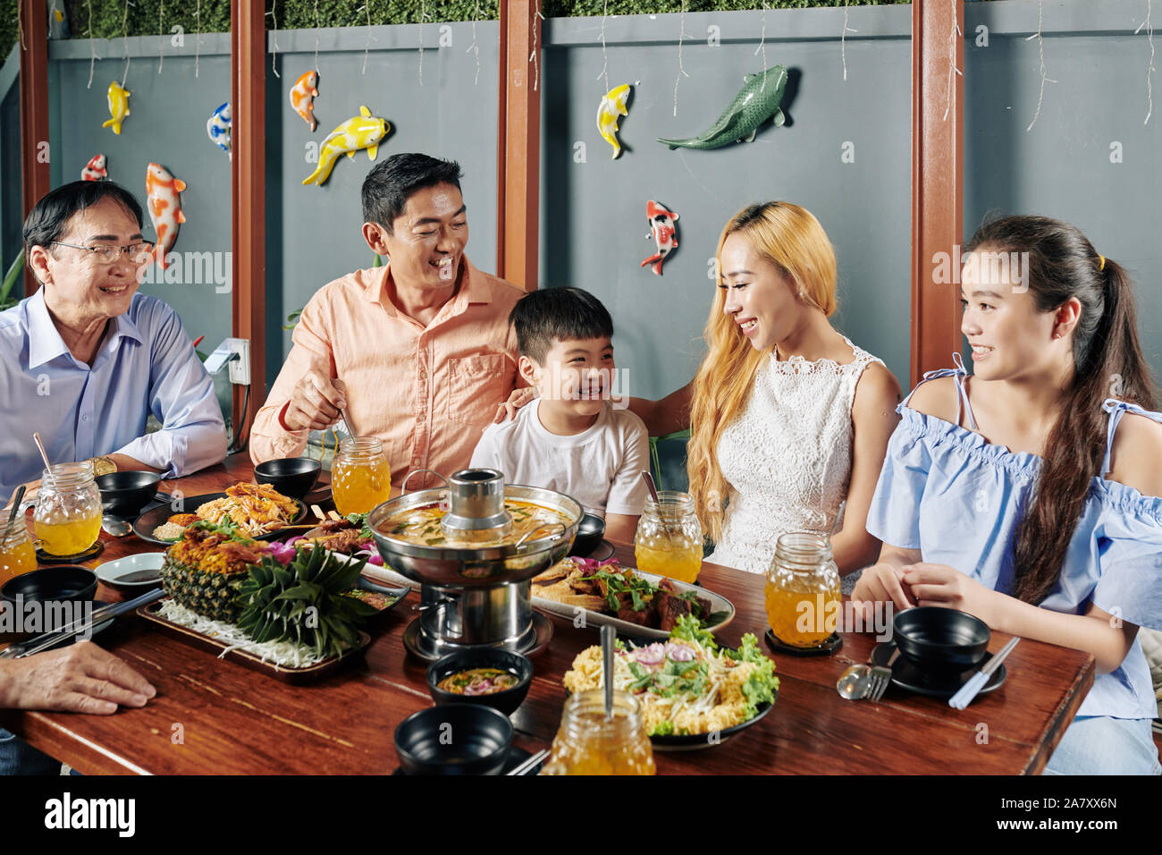 Felice grande famiglia asiatica di gustare la cena in ristorante insieme e mangiare piatti tradizionali Foto Stock