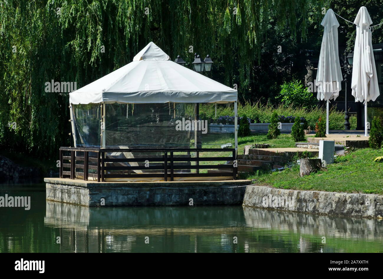 Un luogo accogliente per una distensione estiva con un amico sotto l'ombrellone in Ariana Lago, Parco Borisova Gradina, Sofia, Bulgaria Foto Stock