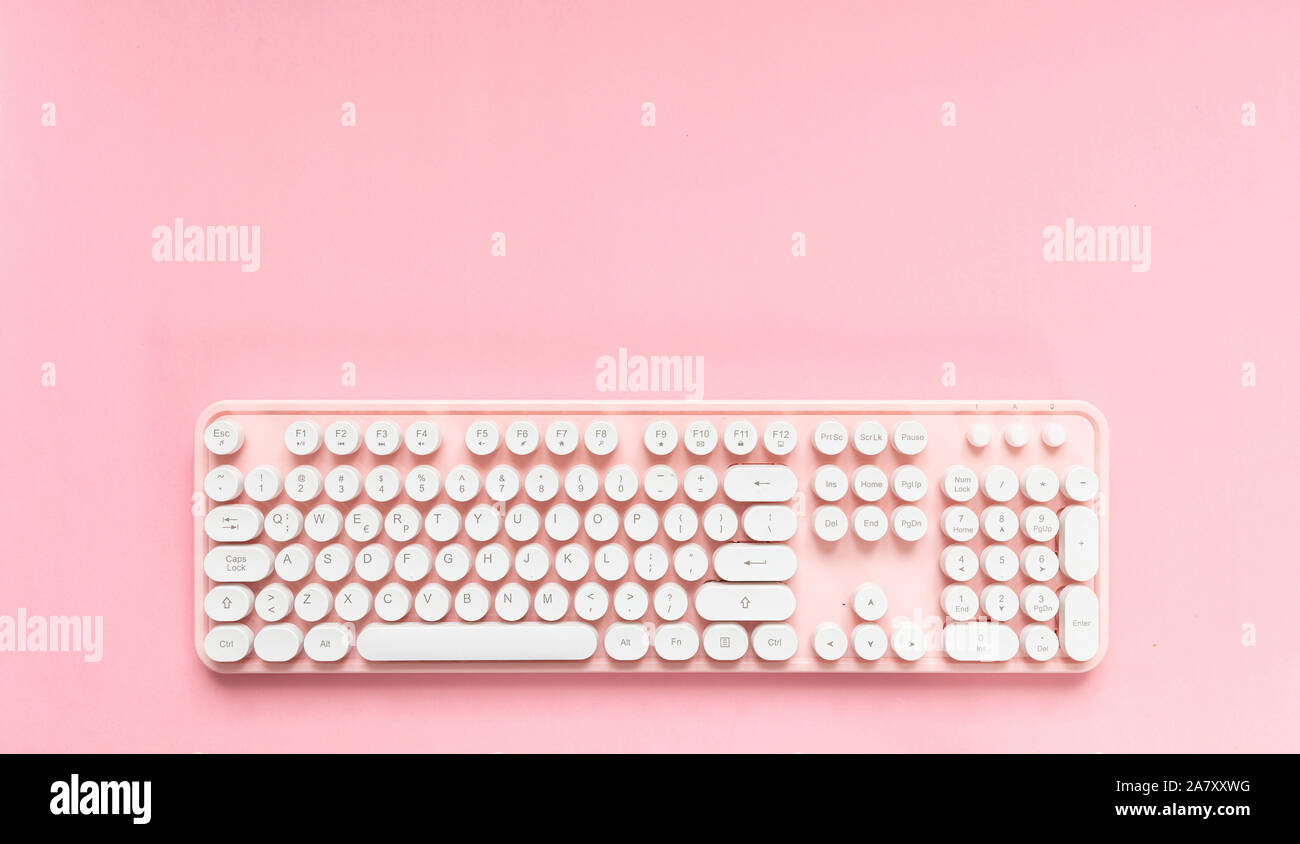 Tastiera per computer rosa con pulsanti bianchi isolati contro sfondo rosa, spazio di copia Foto Stock