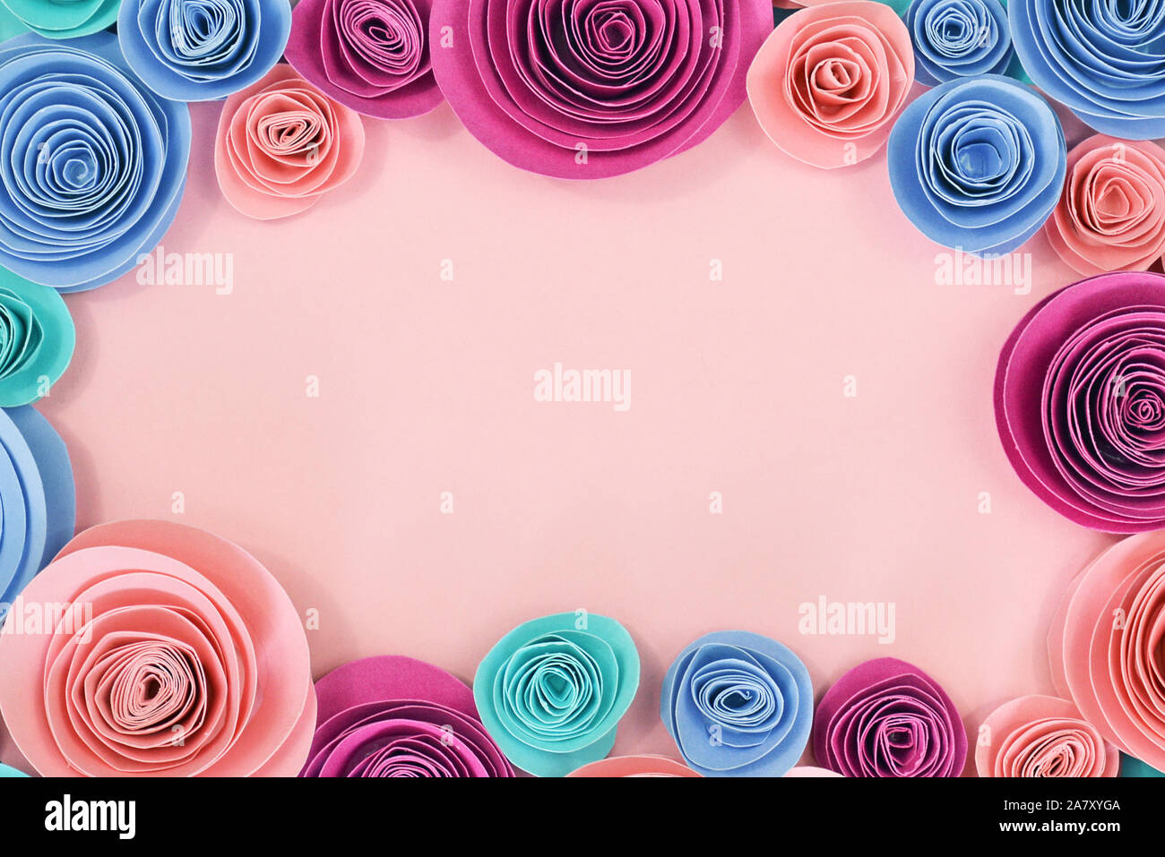 Blu e rosa rosa piatto sfondo laici con predisposti fiori di carta attorno al bordo e vuoto di rosa pastello spazio copia in medio Foto Stock