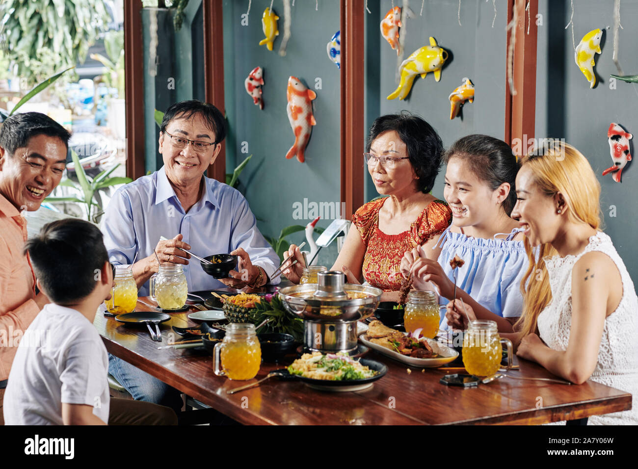 Felice grande famiglia asiatica di parlare, ridere e mangiare del buon cibo a cena Foto Stock