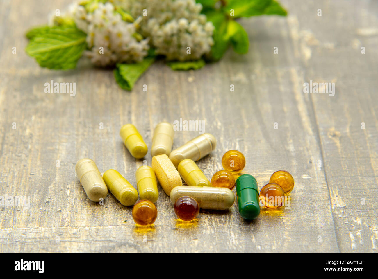 Pillole e capsule di close-up, dietro sfocato delle erbe medicinali. Foto Stock