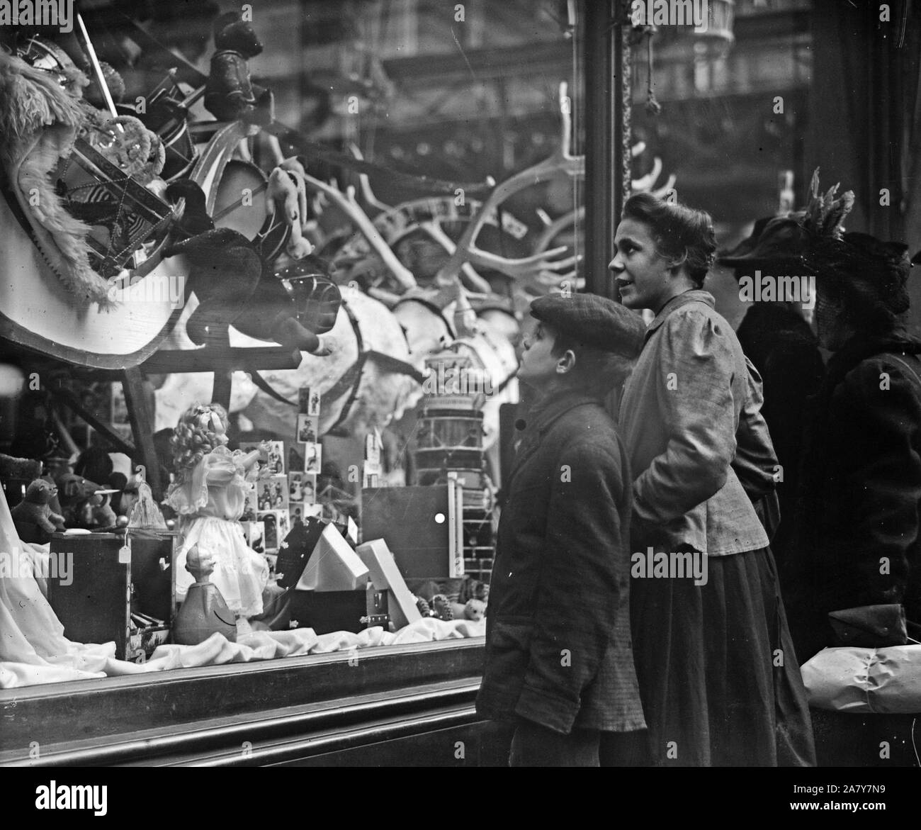 Ragazzo e sua madre guardando Chrismtas giocattoli a finestra del negozio Foto Stock