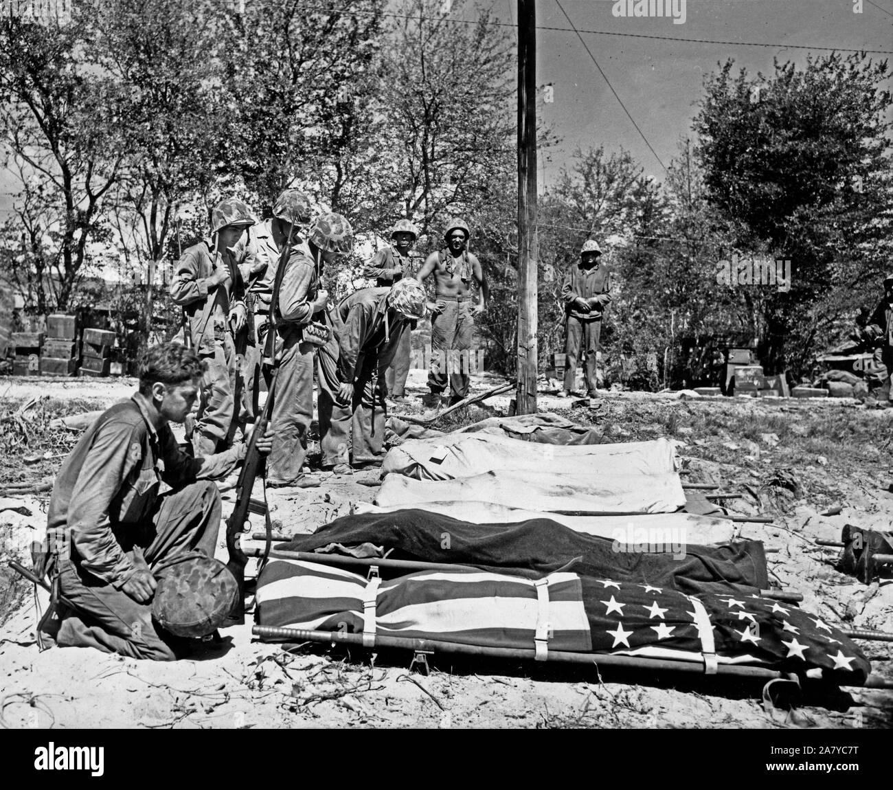 Marines dalla prima ondata di assalto su Saipan, dire addii di compagni caduti che sono preparati per la sepoltura Foto Stock