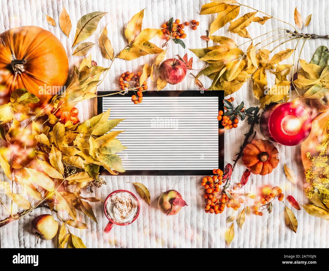 Lettera di bianco in stile scheda con disposizione di autunno: caduta foglie, zucche, tazza di cappuccino, candele accese, mele e rowan. Vista dall'alto. Telaio. Ins Foto Stock