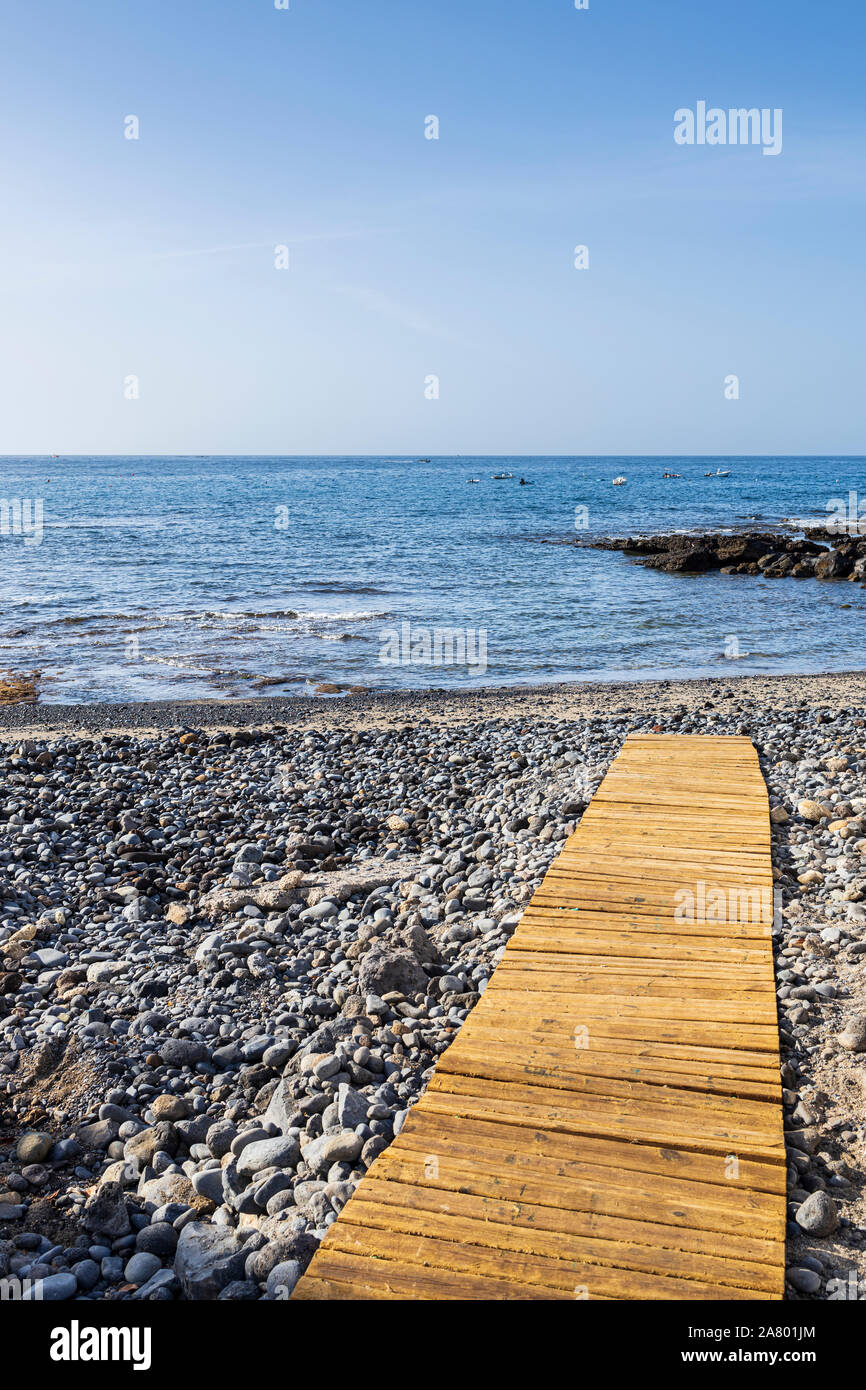 Tavola di legno passerella sulla spiaggia sassosa presso La Caleta, Costa Adeje, Tenerife, Isole Canarie, Spagna Foto Stock