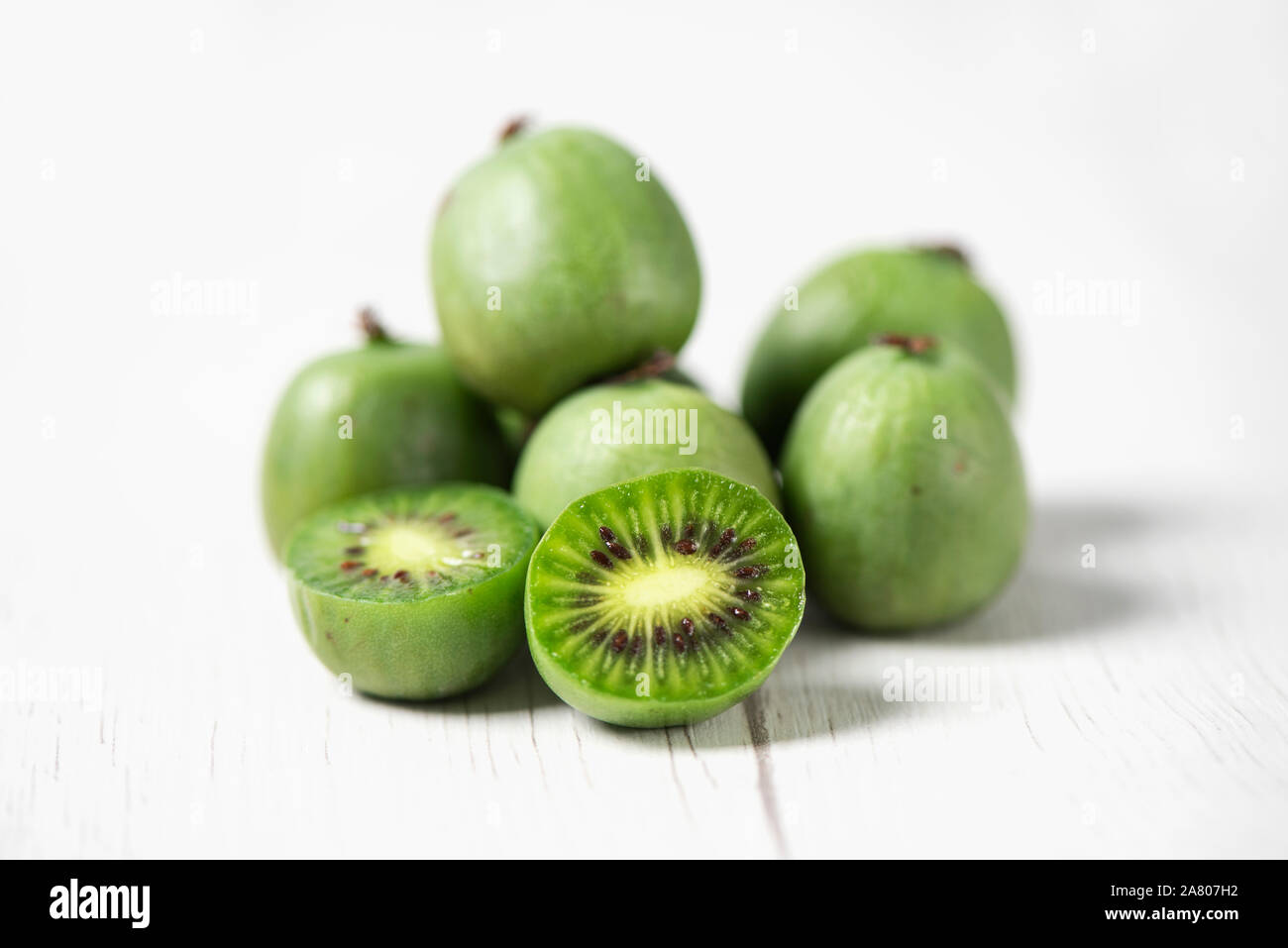 Primo piano di alcuni maturi frutti di bosco kiwi su un bianco tavolo rustico Foto Stock