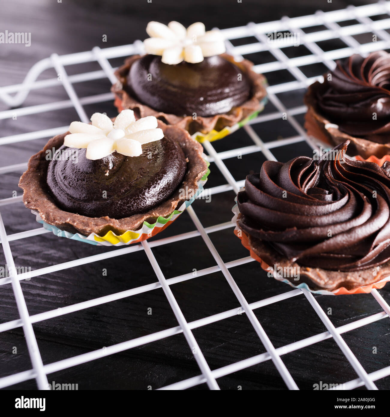 Crostate al cioccolato bianco su rack e su sfondo nero Foto Stock