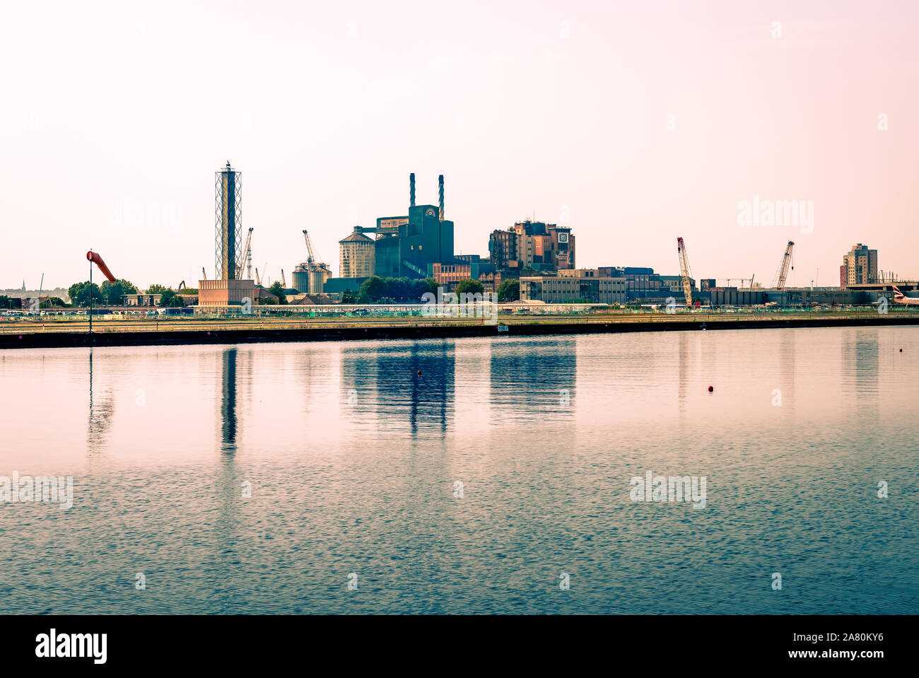 Vista del Royal Docks e la skyline di Silvertown, con Tate and Lyle riflessa in fabbrica sul Tamigi canal, nella zona est di Londra, Inghilterra. Foto Stock