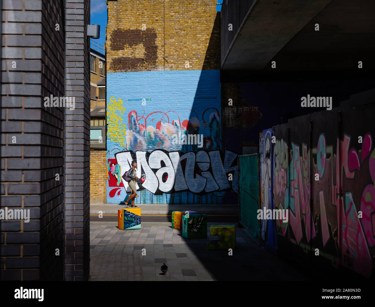 L'uomo passando da colorati graffiti Art di Londra Foto Stock