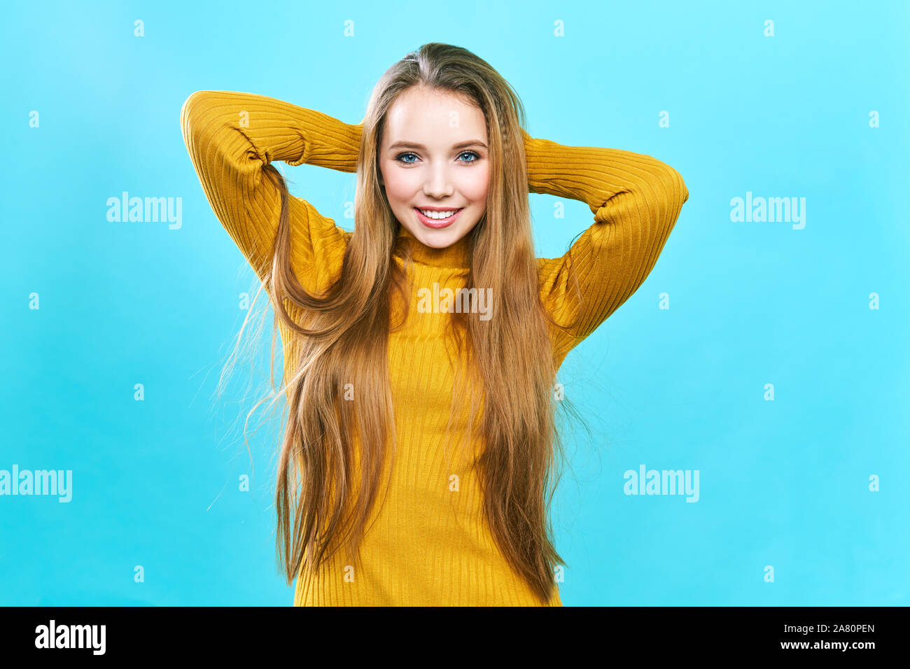 Ritratto di una bella ragazza in un cappello giallo e un maglione, guardando la telecamera e sorridente carino. Foto Stock