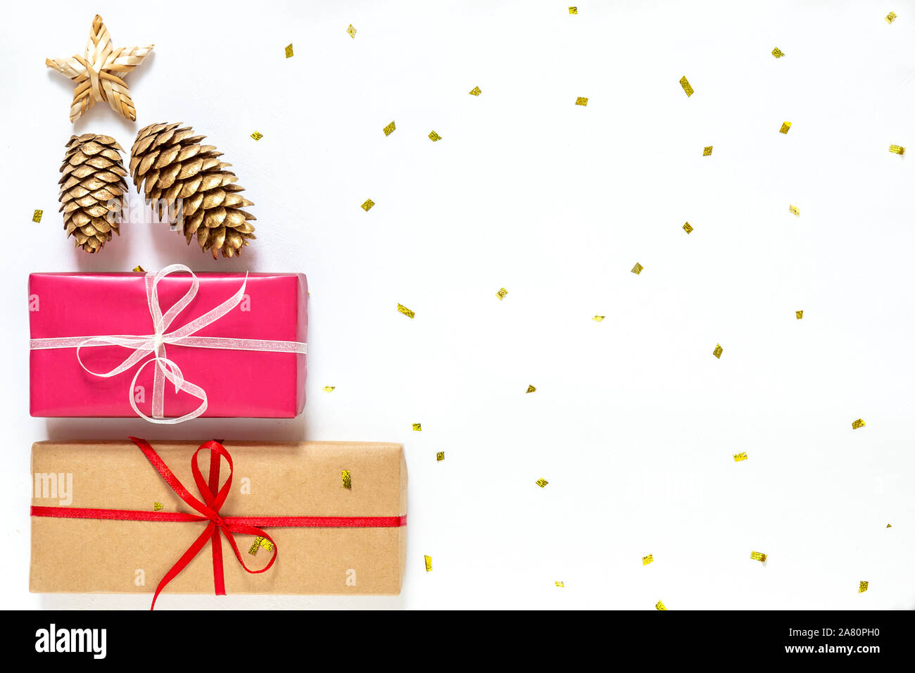 Regalo di natale di scatole con coni d'oro, stella su uno sfondo bianco con oro brilla. Anno nuovo modello di scheda Foto Stock