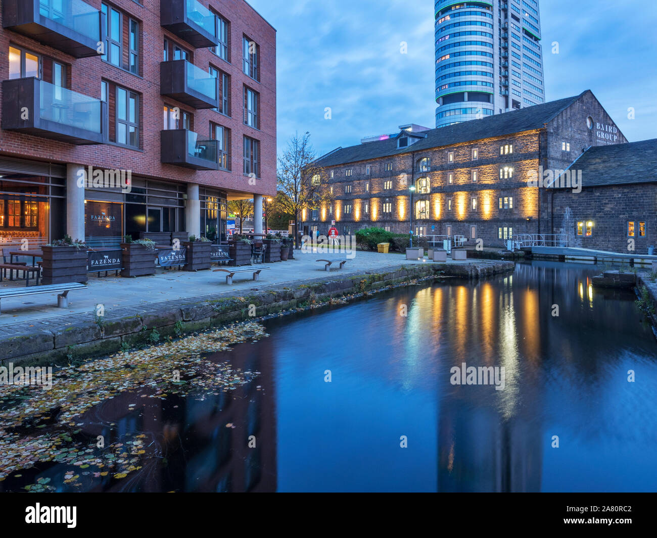 I riflettori Canal magazzino riflessa in Leeds e Liverpool Canal al crepuscolo Granary Wharf Leeds West Yorkshire Inghilterra Foto Stock
