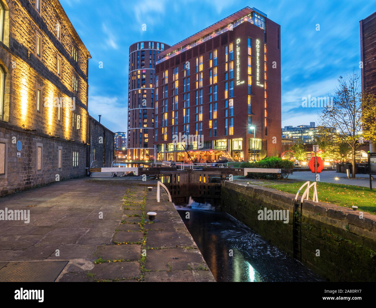 Canale antico magazzino dal fiume di serratura e moderno hotel a Granary Wharf al crepuscolo Leeds West Yorkshire Inghilterra Foto Stock