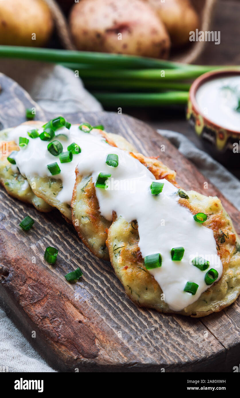 Freschi Fatti in casa in padella frittelle di patate latkes rustico tagliere di legno. Tradizionale cibo ebreo per Hannukah celebrazione. Messa a fuoco selettiva. Foto Stock