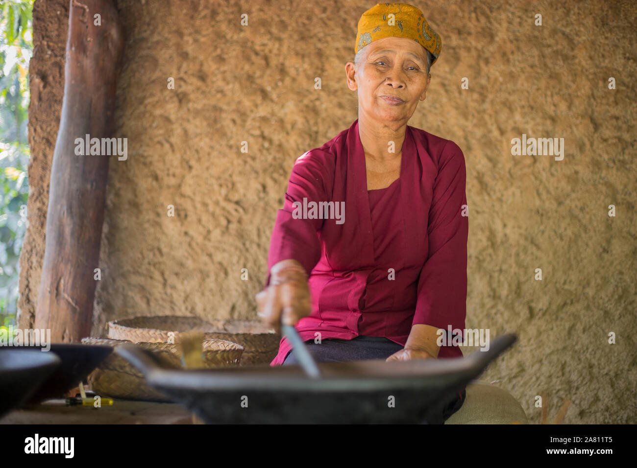 Bali, Indonesia - 13 Settembre 2019: vecchia donna luwak tostatura i chicchi di caffè in Ubud. Luwak caffè è molto costoso e famoso caffè Balinese Foto Stock