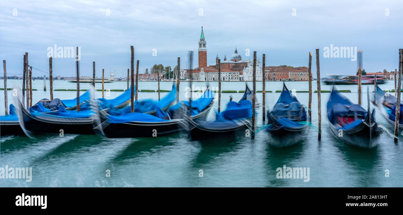 La mattina presto vista di San Giorgio Maggiore da San Marco con gondole attraccate al bordo della laguna di Venezia Italia Foto Stock