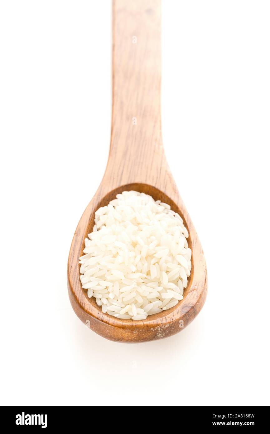 Mucchio di bianco non cotti, crudi riso a grani lunghi in cucchiaio di legno su sfondo bianco Foto Stock