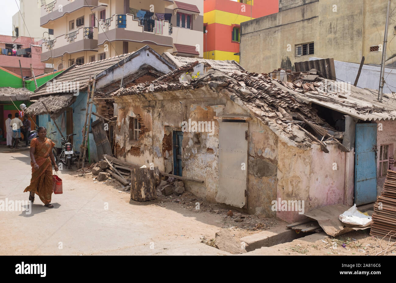 La donna a piedi passato fatiscente casa vecchia di Trichy, Tamil Nadu, India. Foto Stock