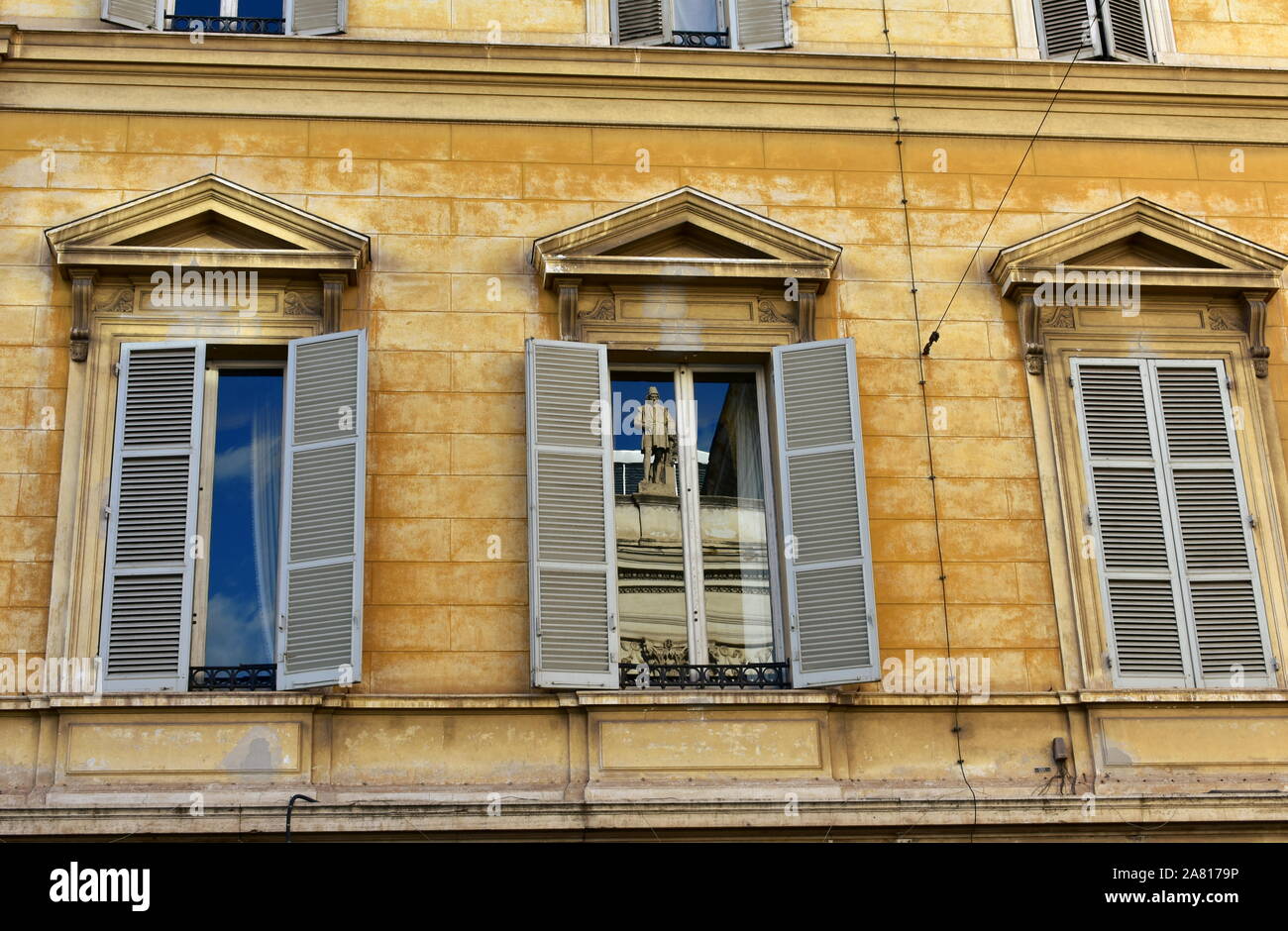 Giallo edificio neoclassico con la scultura la riflessione su una finestra. Roma, Italia. Il 7 ottobre 2019. Foto Stock