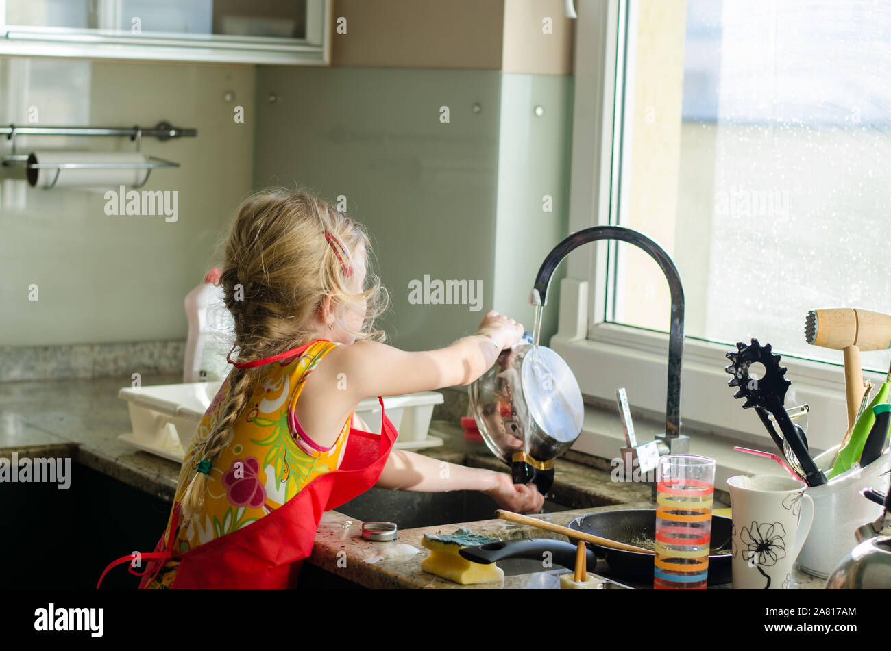 Bambino il lavaggio dei piatti in cucina Foto Stock