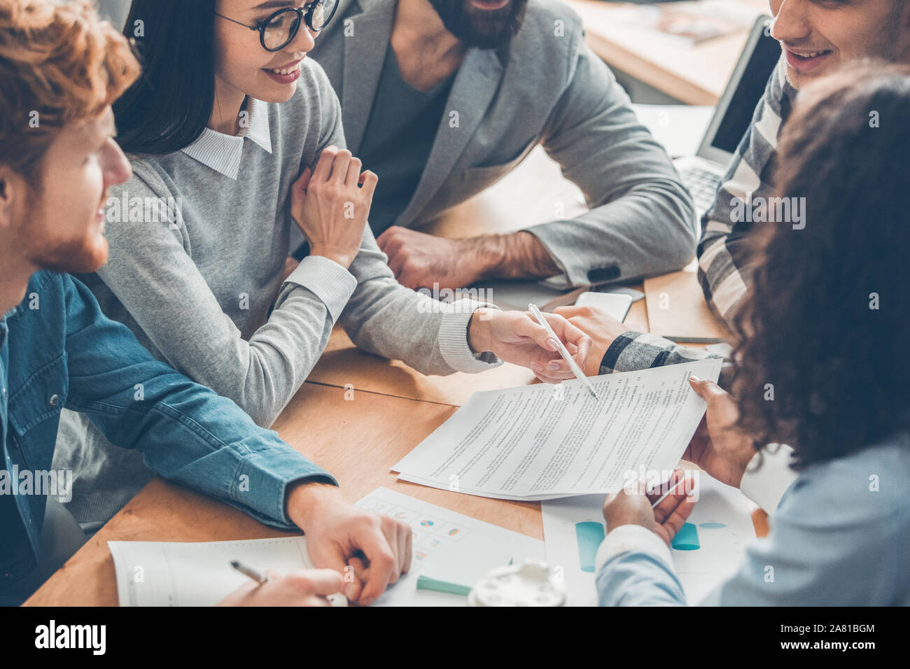 Startupers lavorando insieme in ufficio di affari contratto di lettura gioiosa Foto Stock