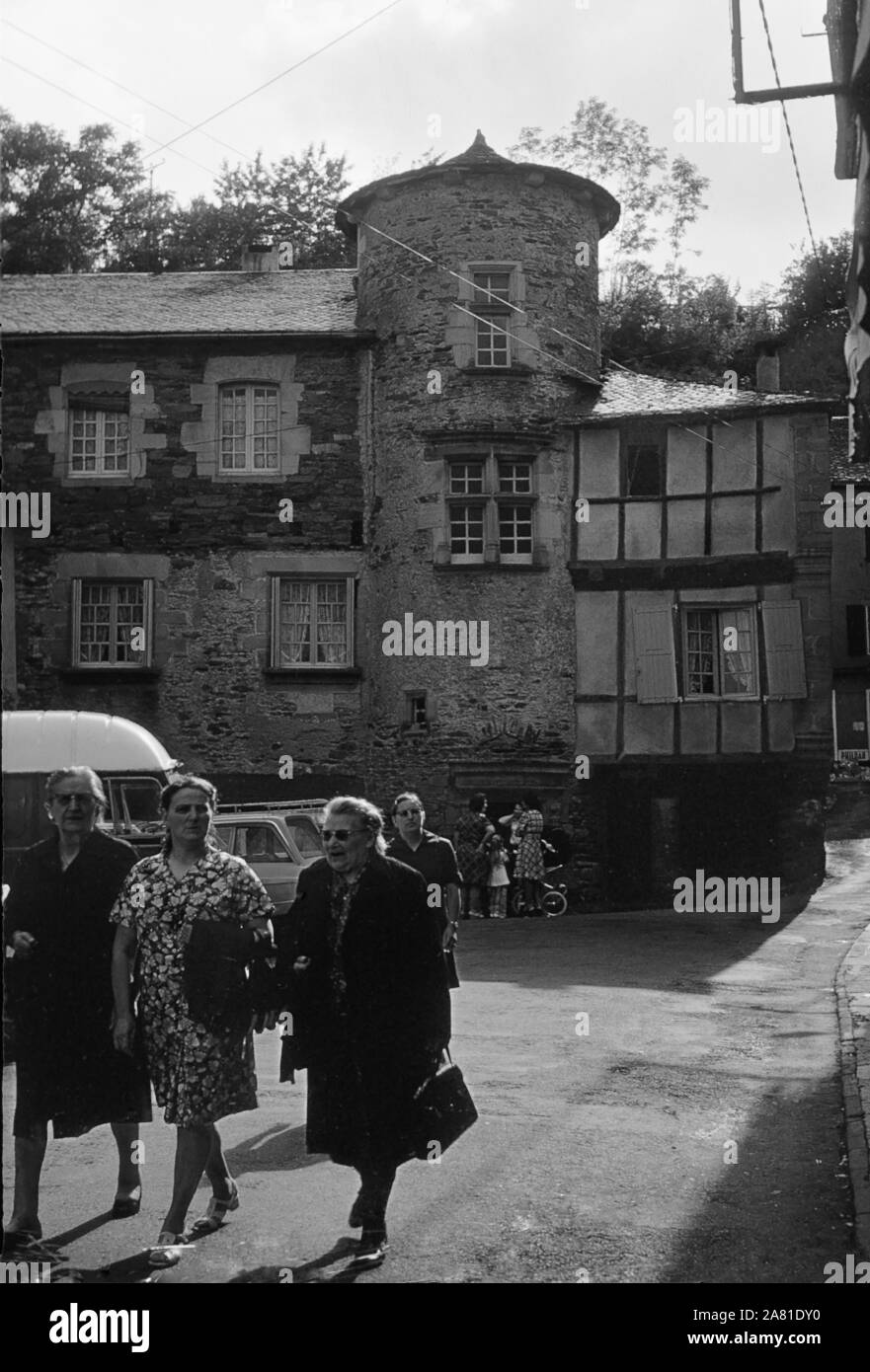 Promenading in piazza, Place du Centre, Coupiac, Aveyron, Occitanie, Francia. Scansione in bianco e nero film negativo, 1968 Foto Stock