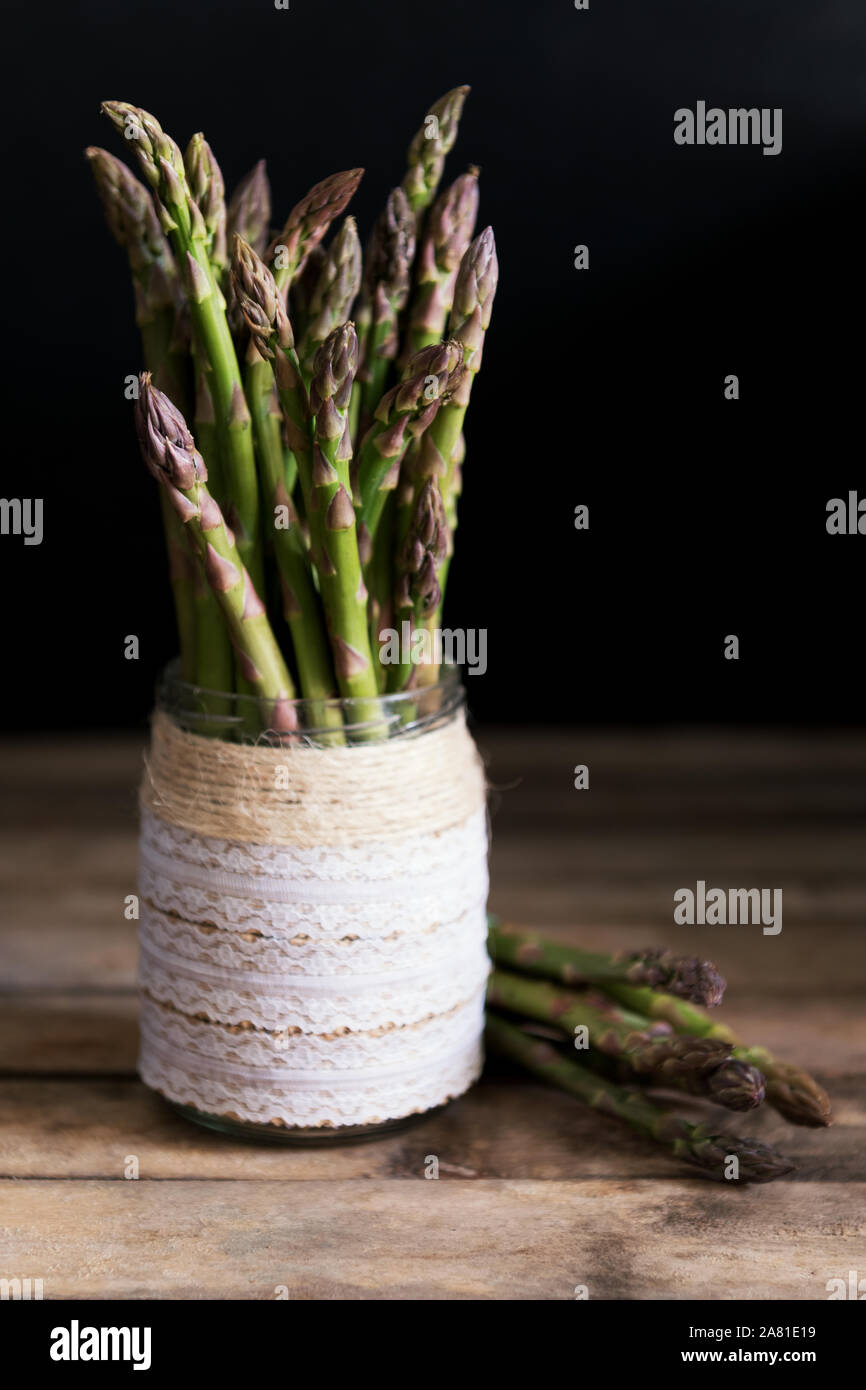 Mazzetto di verde fresco asparagi organico su un sfondo di legno. Cibo sano, dieta e detox prodotto, una fonte di calcio e di fosforo. Foto Stock