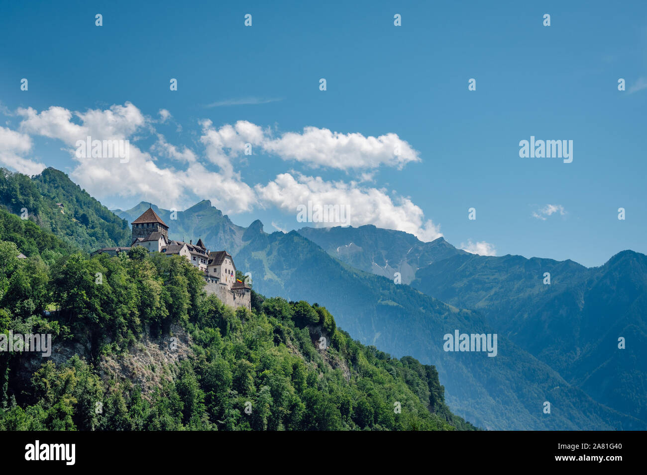 Il castello di Vaduz nel capitale di Liechtenstein, estate vista con le Alpi e il cielo blu con nuvole bianche in background. Foto Stock