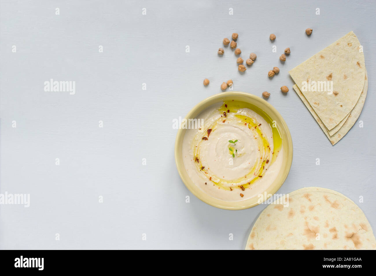 In casa hummus, ceci, dip con spezie nella ciotola e pane taco . Cibo decorate con ceci e olio d'oliva .vegetariano cibo sano concetto Foto Stock