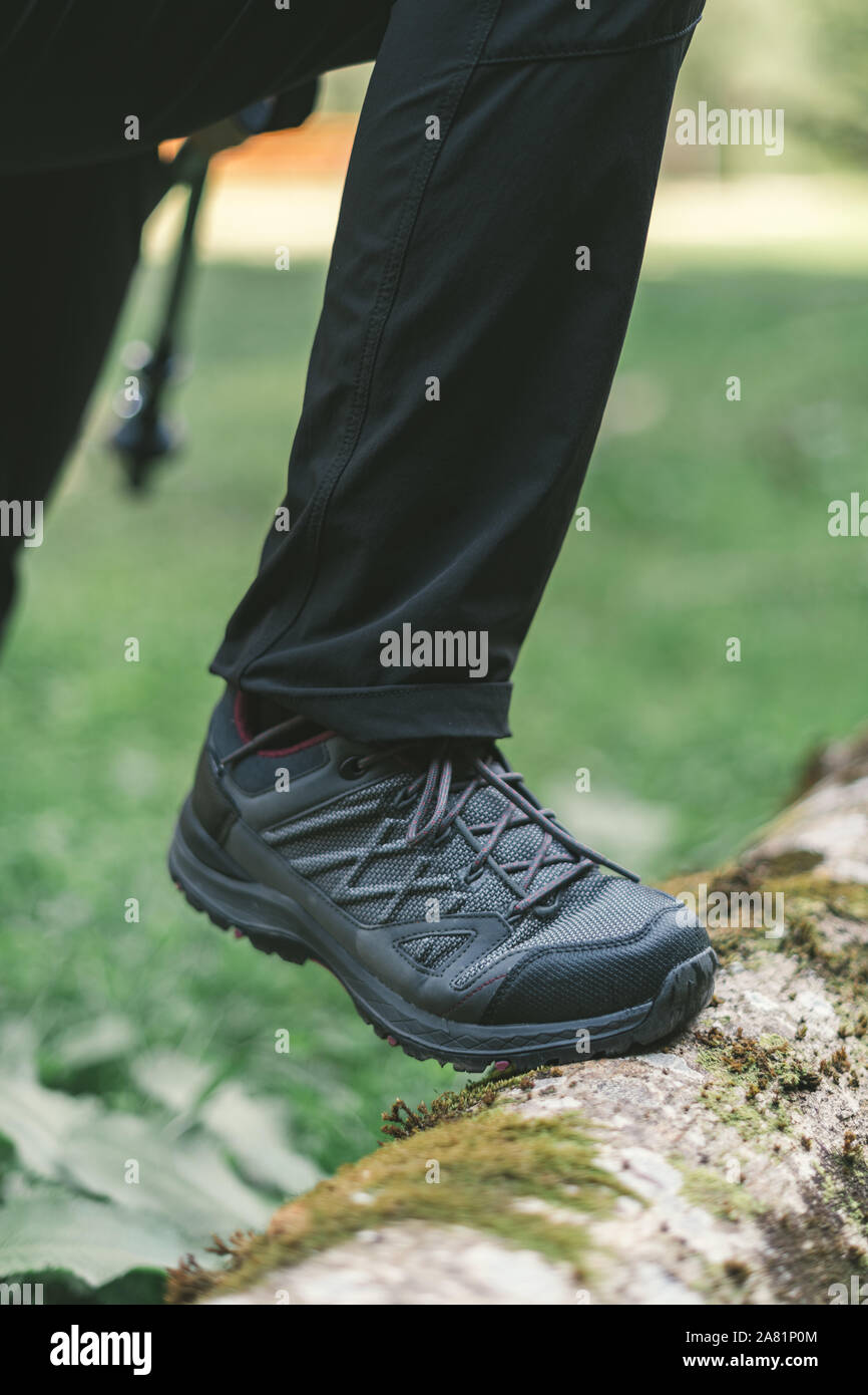 Escursionismo calzatura trekking nei boschi, il fuoco selettivo della femmina piedi degli escursionisti a piedi nella foresta Foto Stock